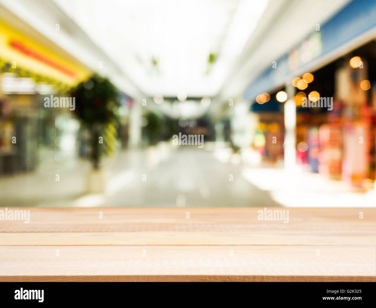 Placa de madera tabla vacía delante de fondo borroso. Perspectiva sobre madera ligera borrosidad en shopping mall - puede utilizarse para dis Foto de stock