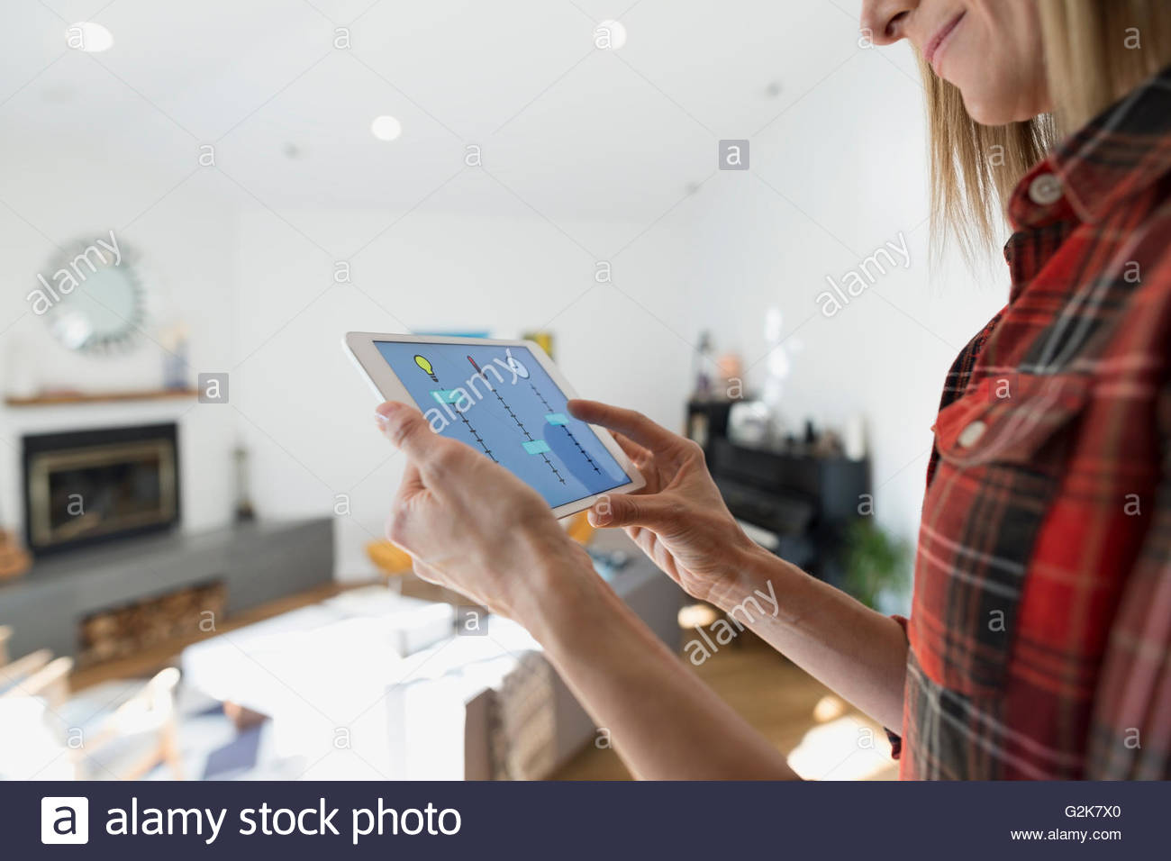 Mujer controlar home utilidades con tableta digital Foto de stock