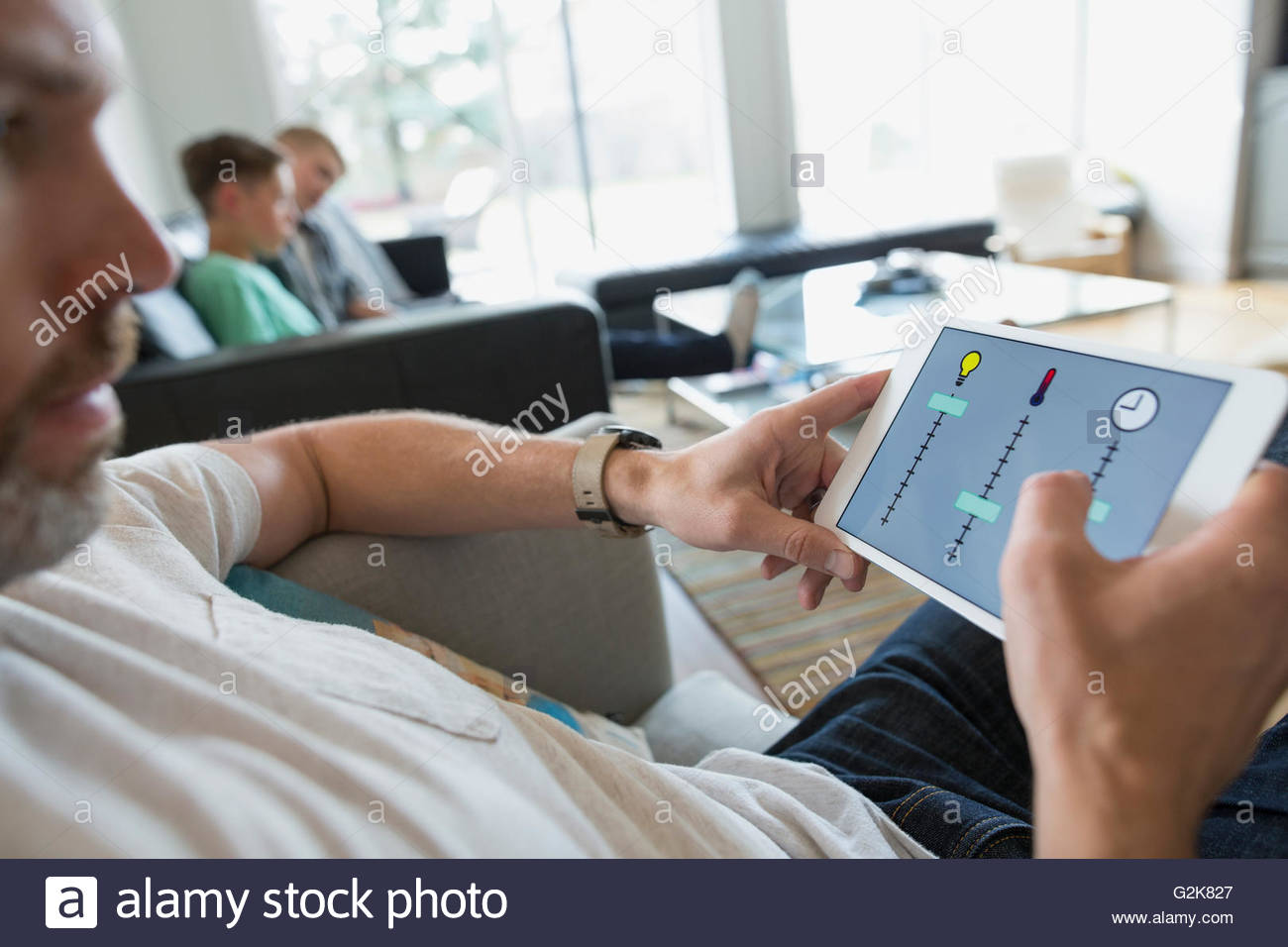 El hombre controlar home utilidades en tableta digital Foto de stock
