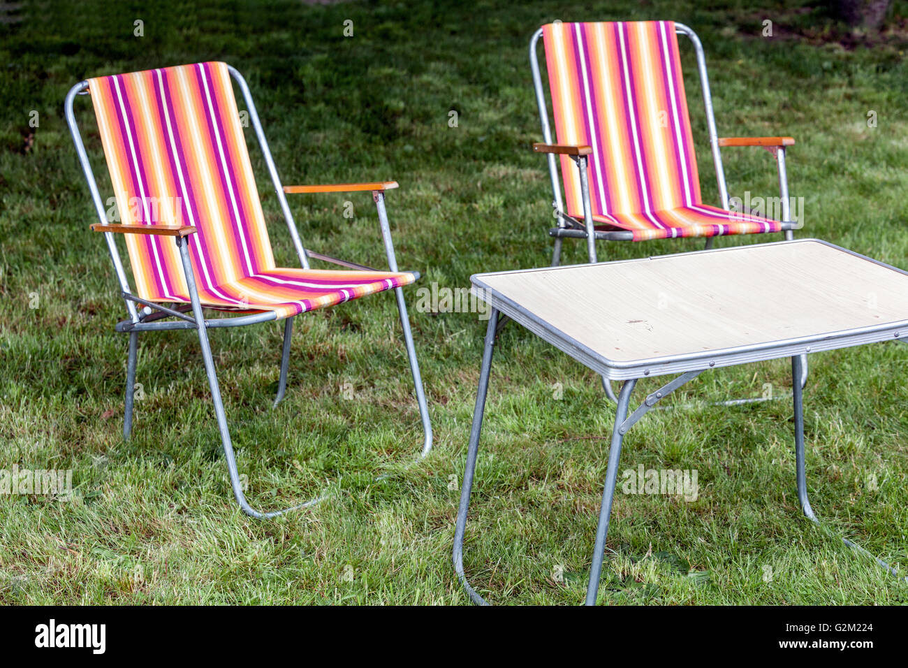 Camping sillas plegables en una pradera verde Foto de stock