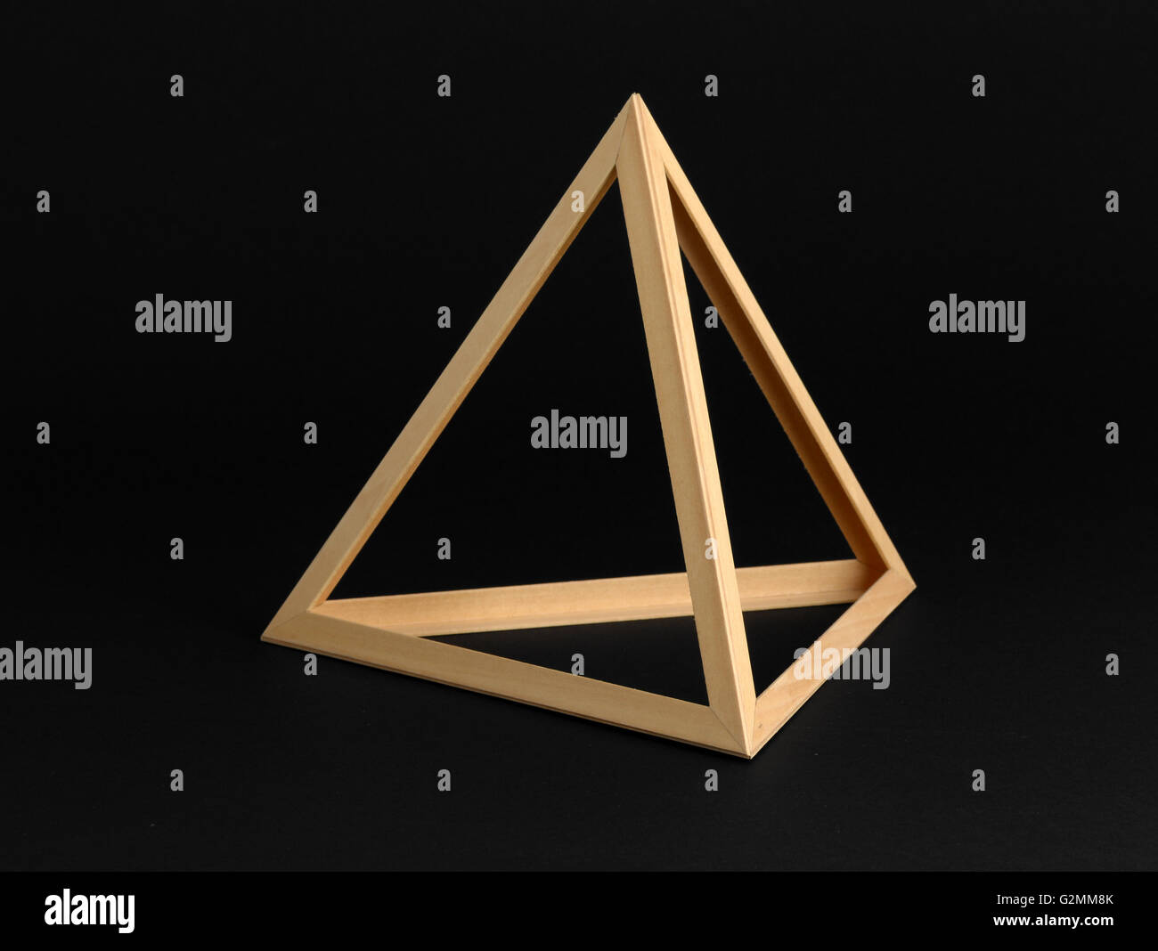 Tres dimensiones geométricas bastidor triangular de madera aislado en un fondo negro Foto de stock