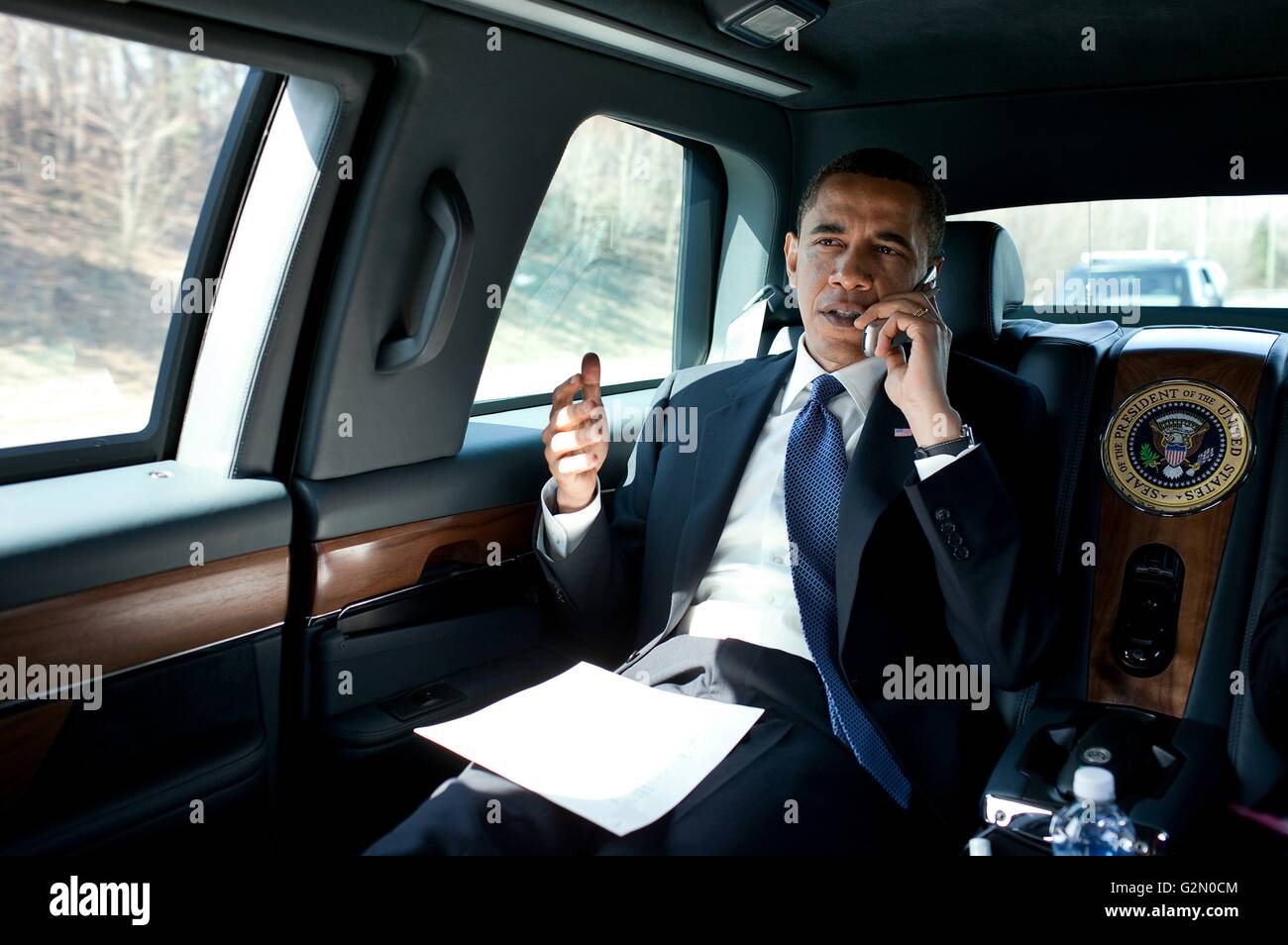 Barack Hussein Obama II (nacido el 4 de agosto de 1961); el 44º Presidente de los Estados Unidos, habla por teléfono en la limusina presidencial de 2013. Foto de stock