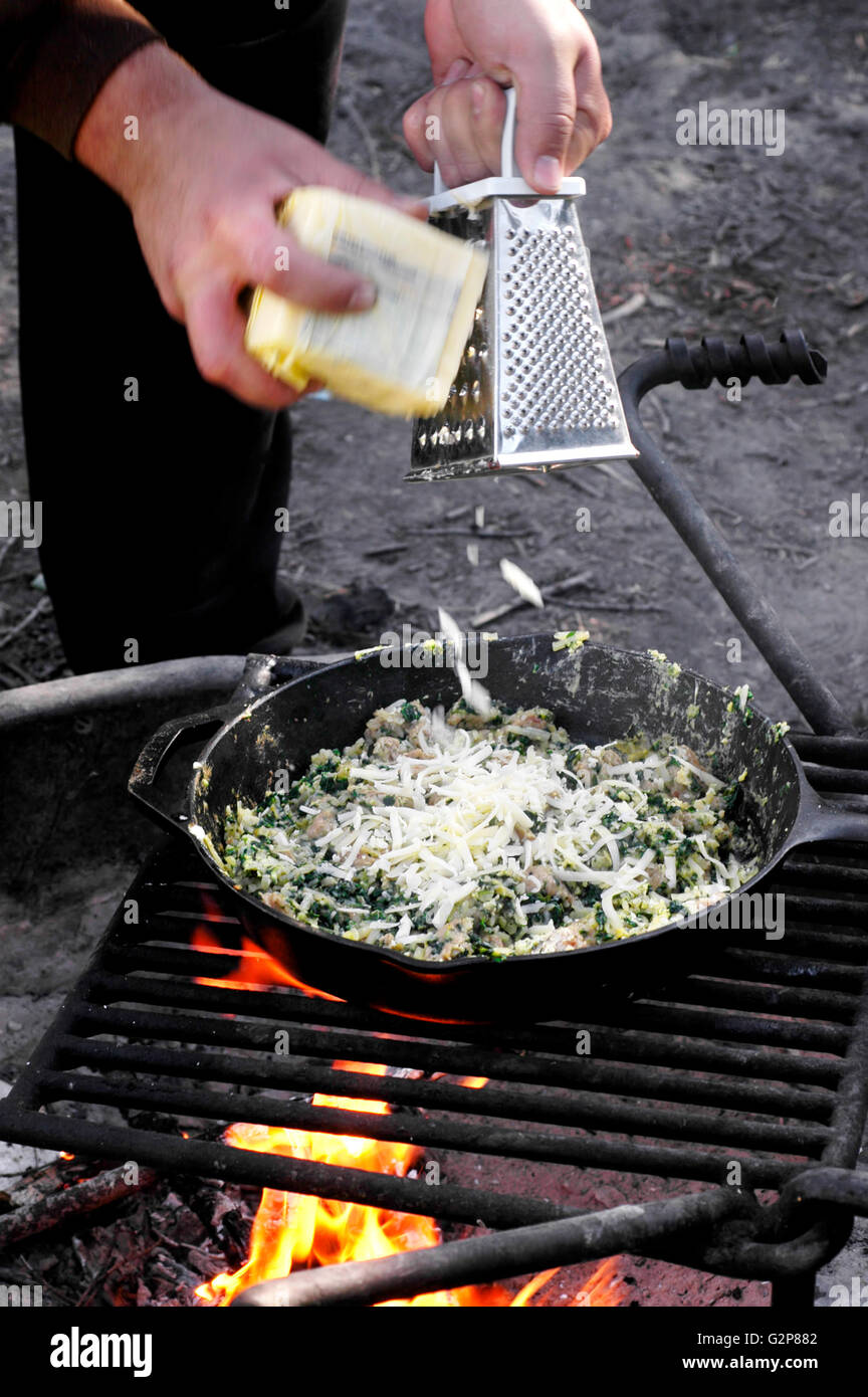 Salchichas espinacas y huevo cocido trepar a través de una parrilla de CAMPFIRE Foto de stock