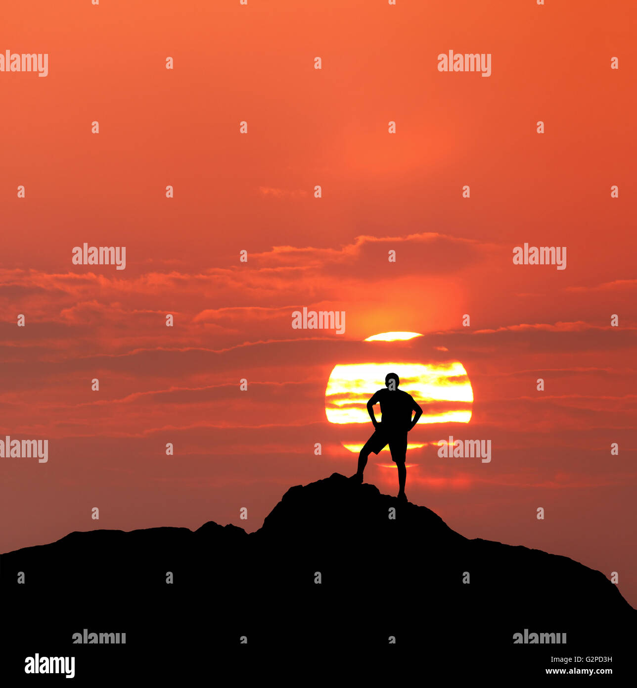 Puesta de sol paisaje con la silueta de un escalador permanente con mochila en el fondo del disco solar y coloridos cielo rojo en suma Foto de stock