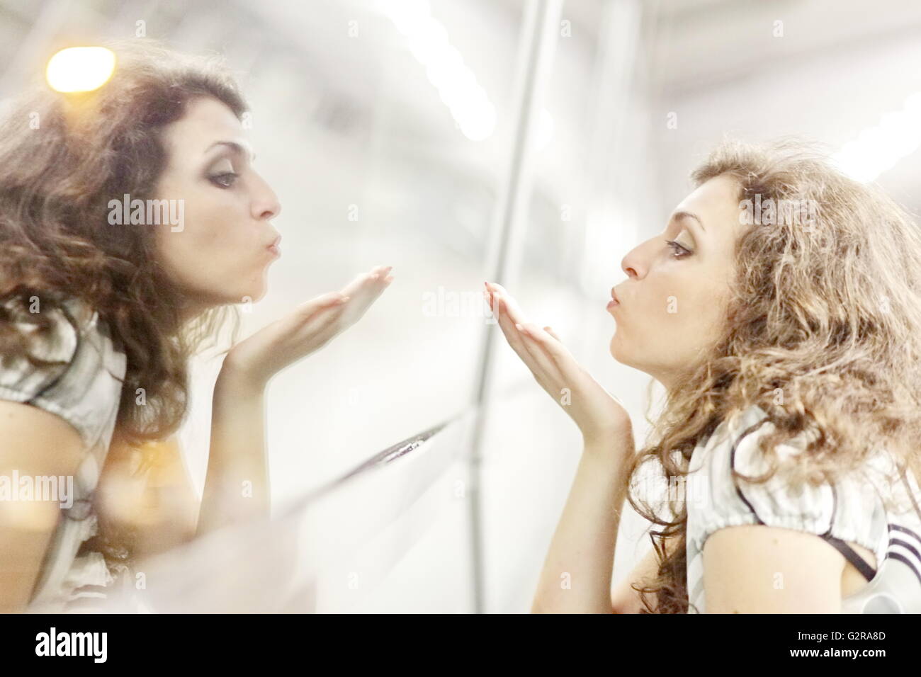 Mujer soplando un beso a su imagen de espejo, Allgaeu, Kempten, Allgäu, suabia, Baviera, Alemania Foto de stock