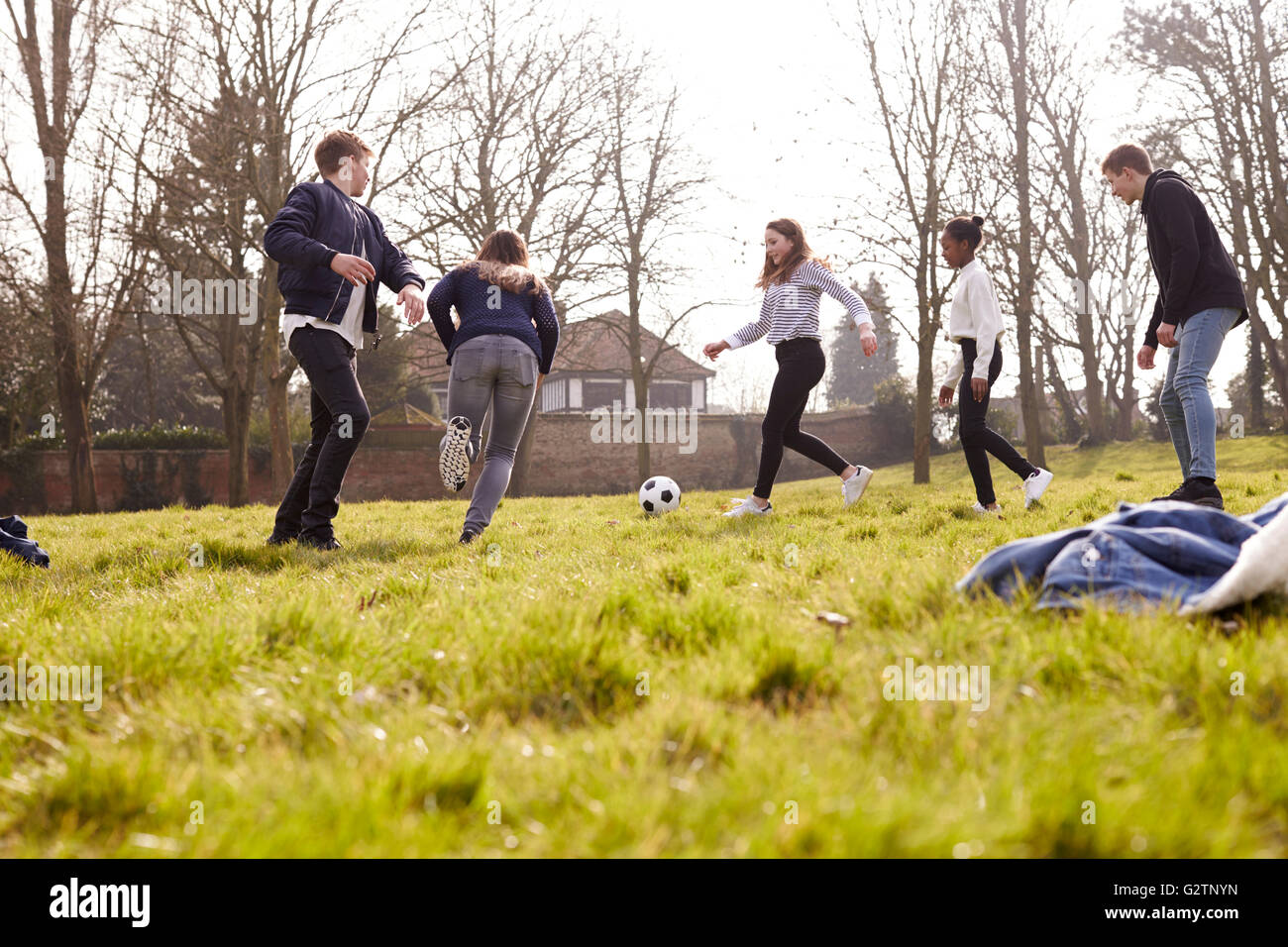 Grupo de adolescentes jugando fútbol en el parque Foto de stock