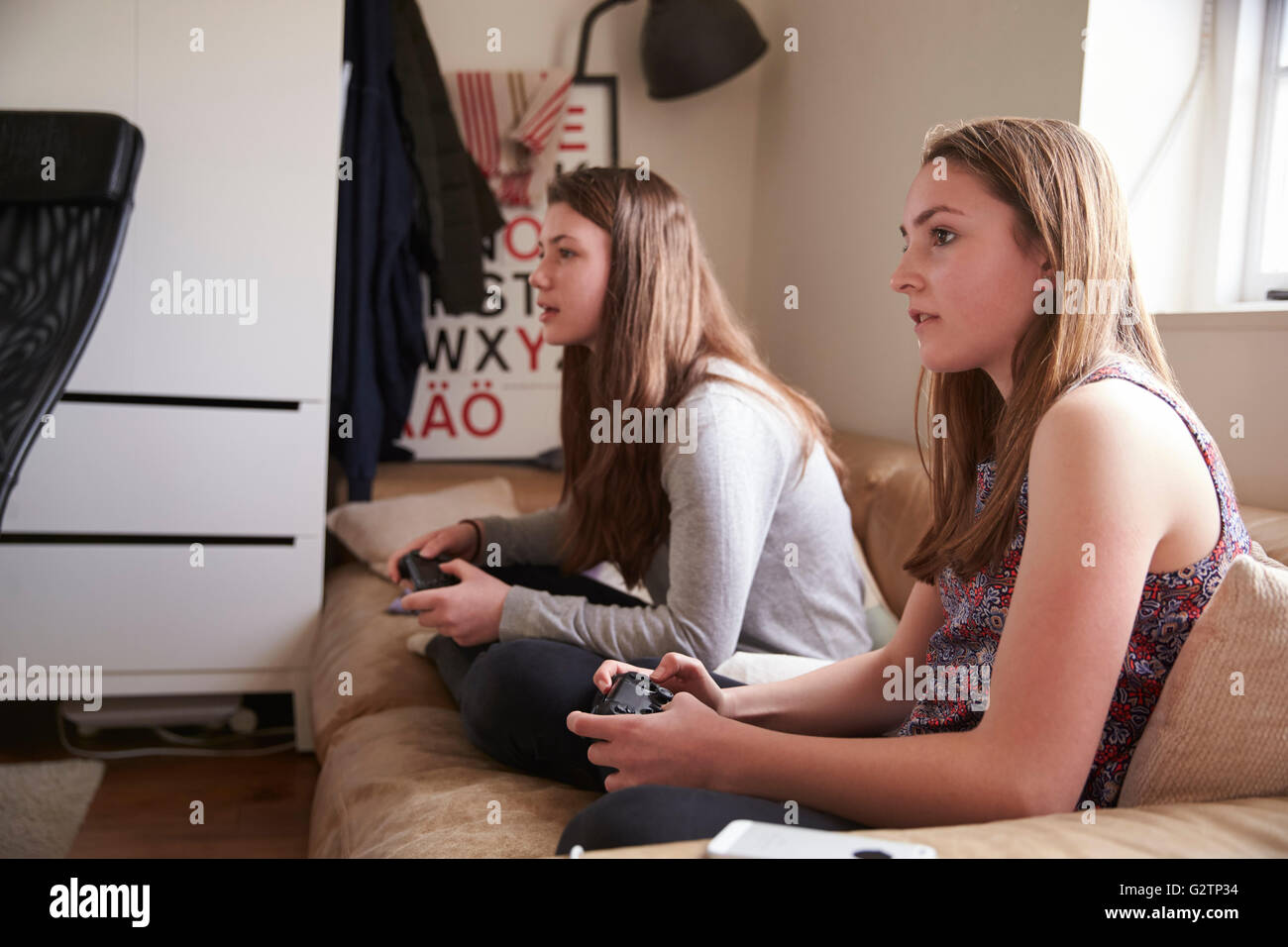 Dos chicas adolescentes jugando juegos de video en el dormitorio Fotografía  de stock - Alamy