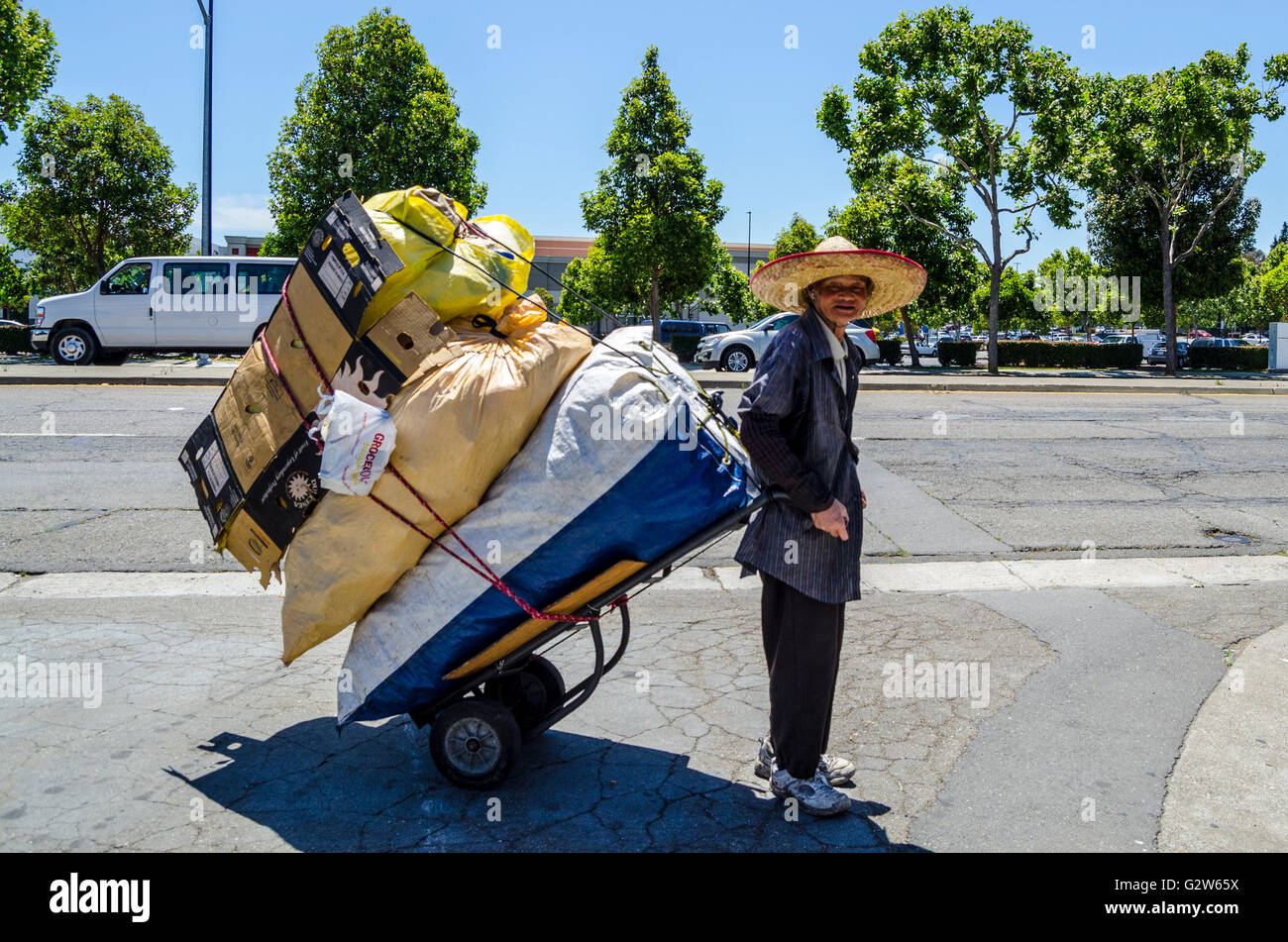 Un trabajo duro hombre asiático recogida reciclables en San Leandro, California Foto de stock