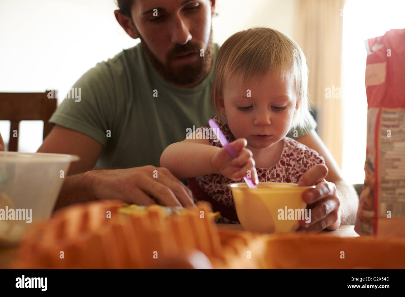 Padre con hija en casa Horneando bizcochos juntos Foto de stock
