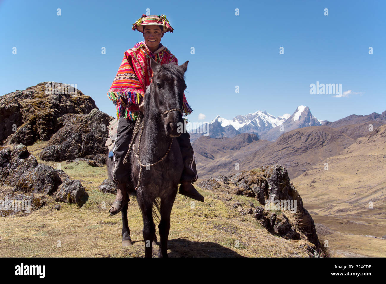 Guía de montaña indio con poncho colorido rutas a caballo en las montañas de los andes, Lares, cerca de Cusco, Peru. Foto de stock