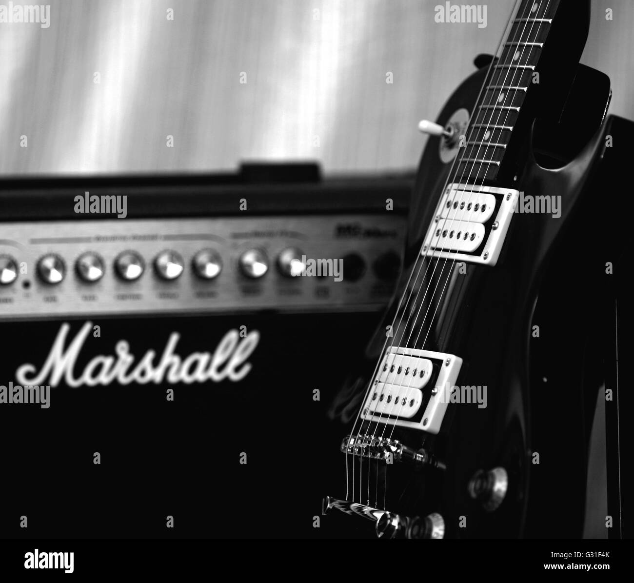 Un negro Encore estilo Les Paul guitarra eléctrica con un amplificador  Marshall - Classic Fotografía de stock - Alamy