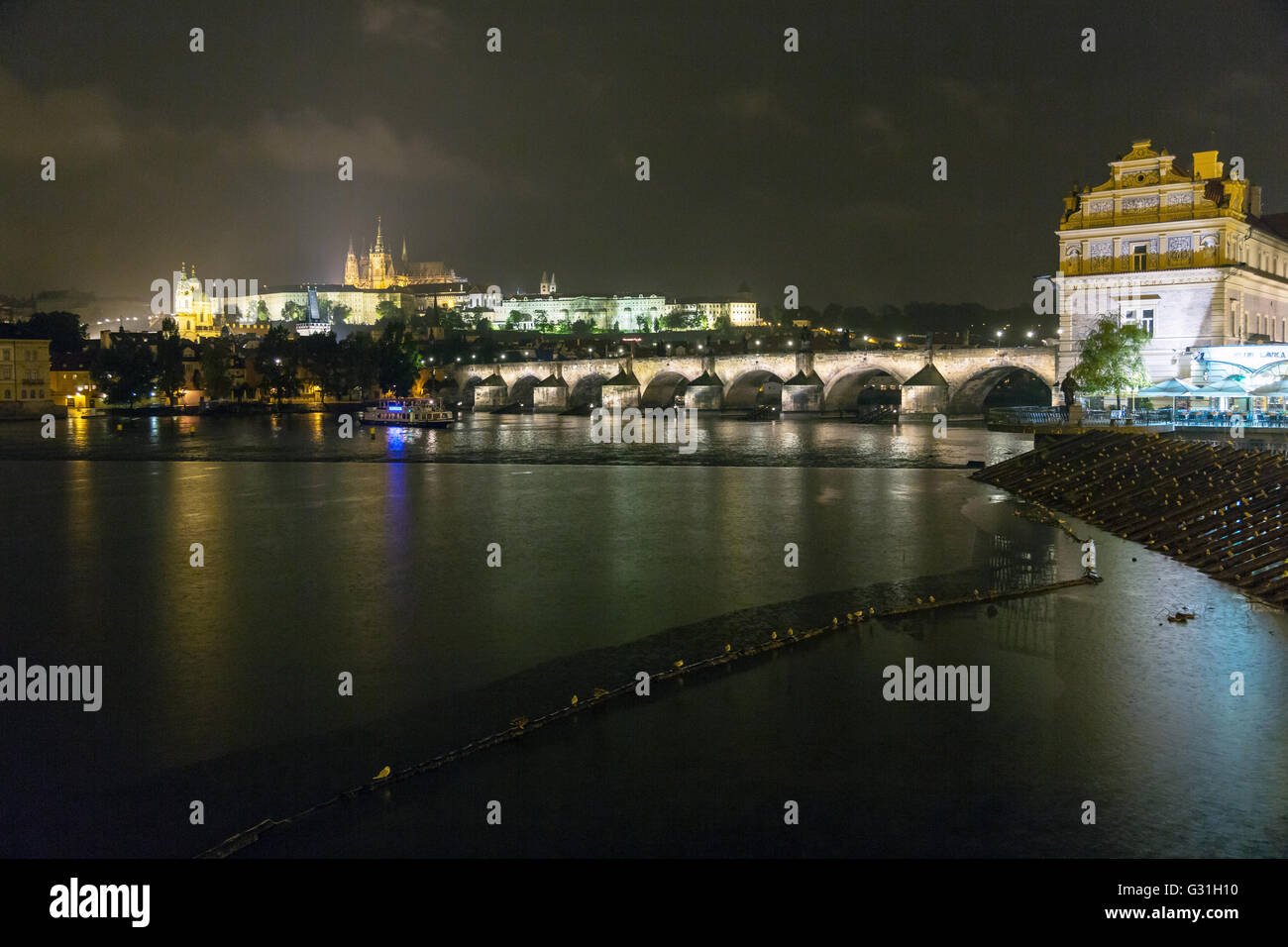 Praga, República Checa, vista sobre el río Moldava por el Puente de Carlos y el Castillo de Praga por la noche Foto de stock