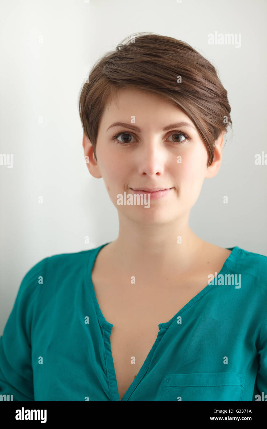 Encantador pelo corto mujer sin maquillaje sobre fondo blanco. Foto de stock