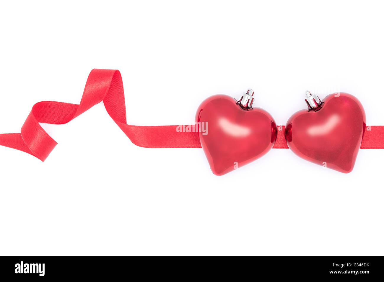 Celebrar el Día de San Valentín, corazones y el lazo rojo sobre fondo blanco. Foto de stock