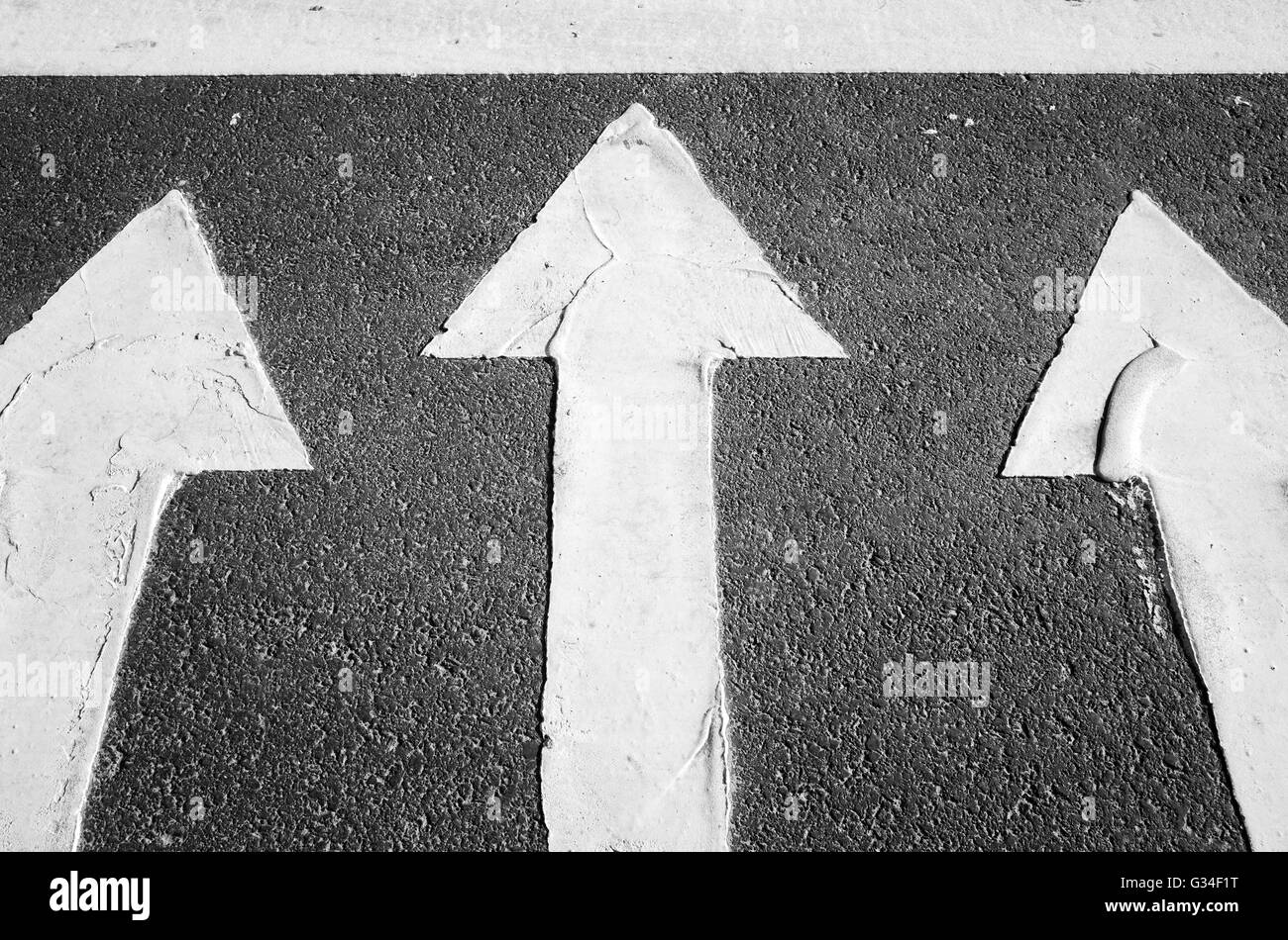Las flechas de color blanco sobre el negro asfalto de carretera, cruce de peatones carretera fragmento de marcado Foto de stock