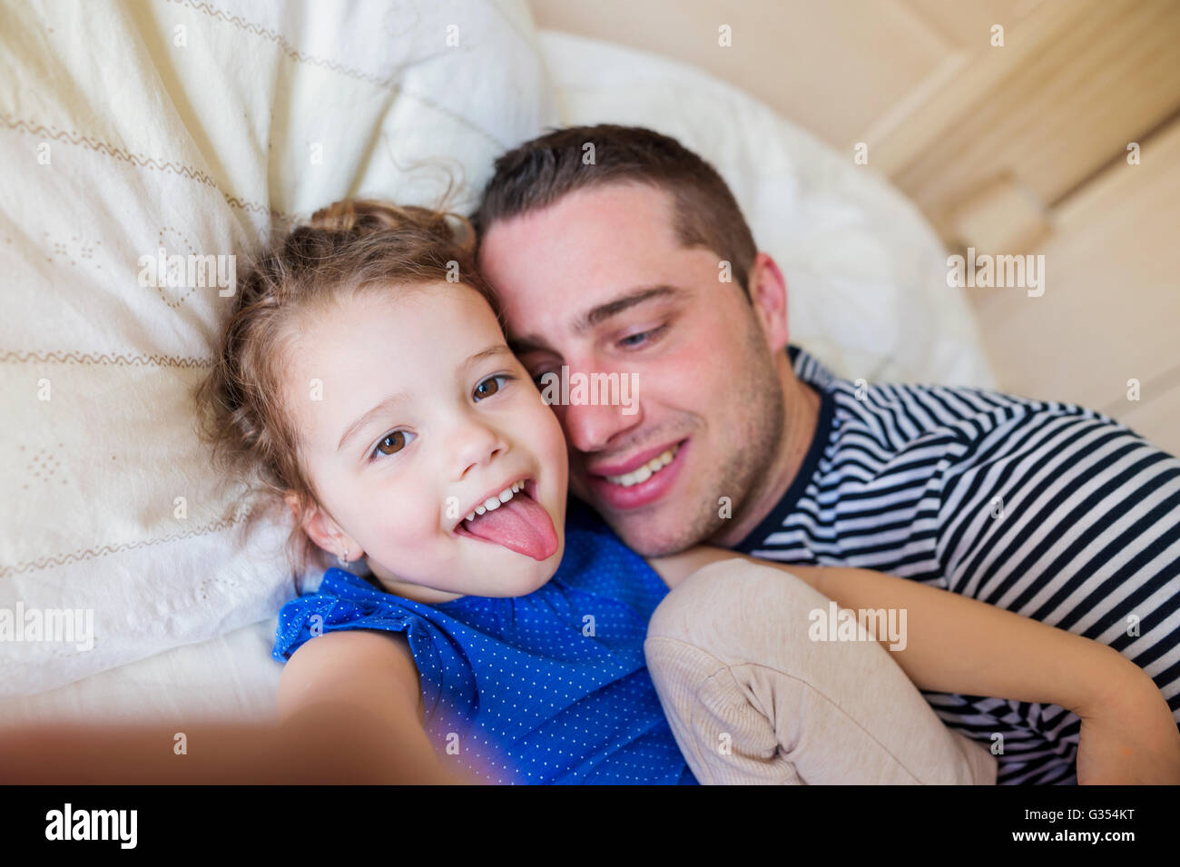 Padre E Hija Acostada En La Cama De Sus Padres Teniendo Selfie Fotografía De Stock Alamy