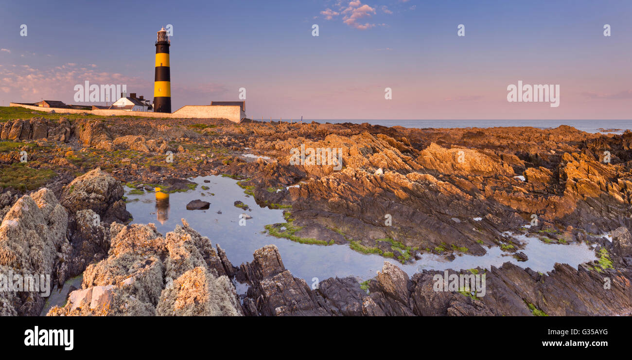 El Saint John's Point Lighthouse en Irlanda del Norte fotografiado al atardecer. Foto de stock