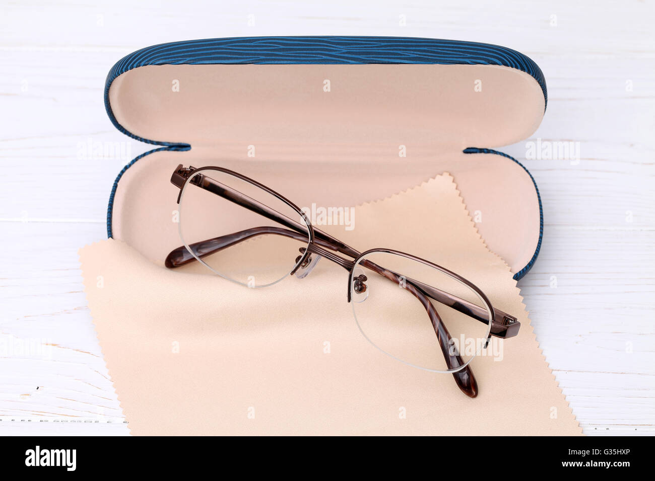 Gafas y caso con gafas, paño de limpieza en la mesa de madera blanca  Fotografía de stock - Alamy