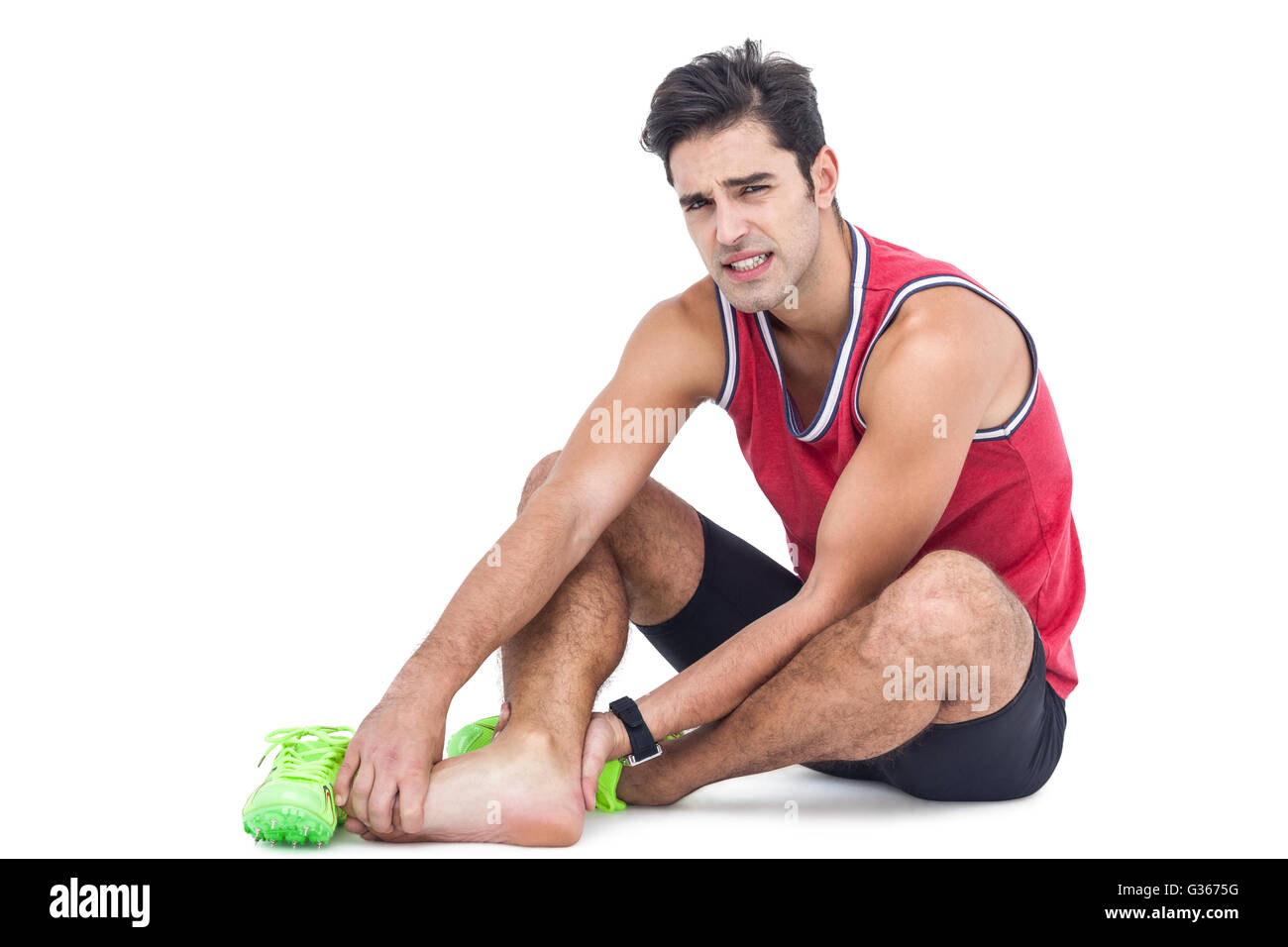 Retrato de atleta masculino con dolor de pie sobre fondo blanco. Foto de stock