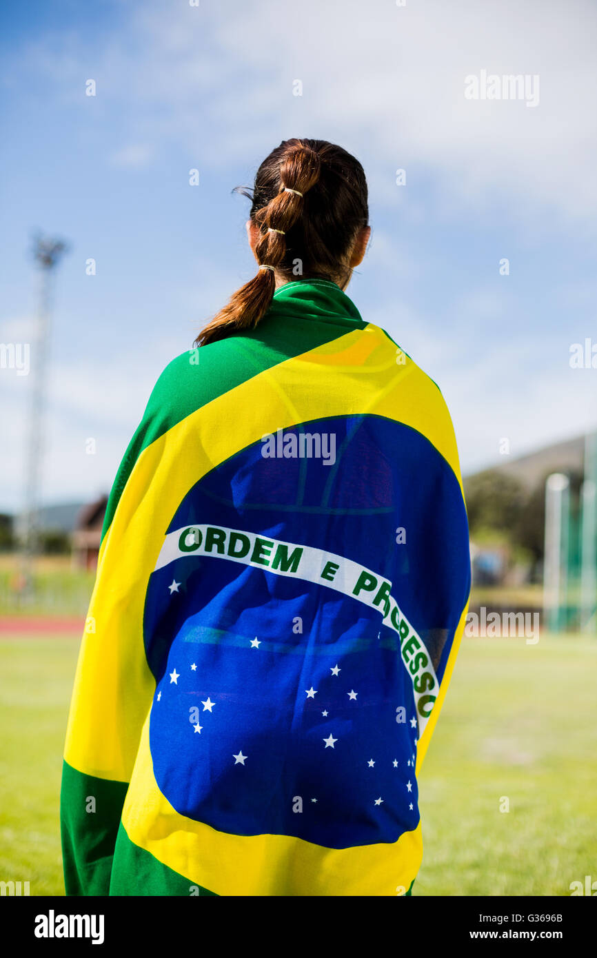 Atleta Femenina envueltos en la bandera brasileña Foto de stock