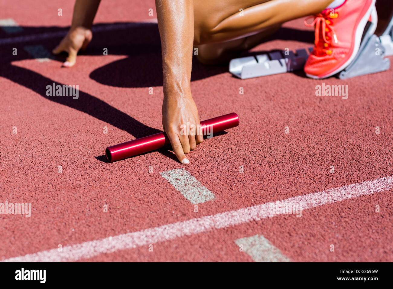 Atleta Femenina listo para empezar la carrera de relevos Foto de stock