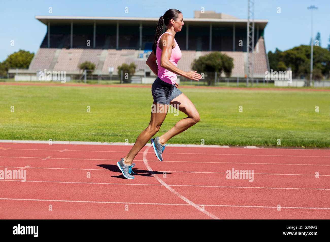 Atleta Femenina corriendo en la pista de atletismo Foto de stock