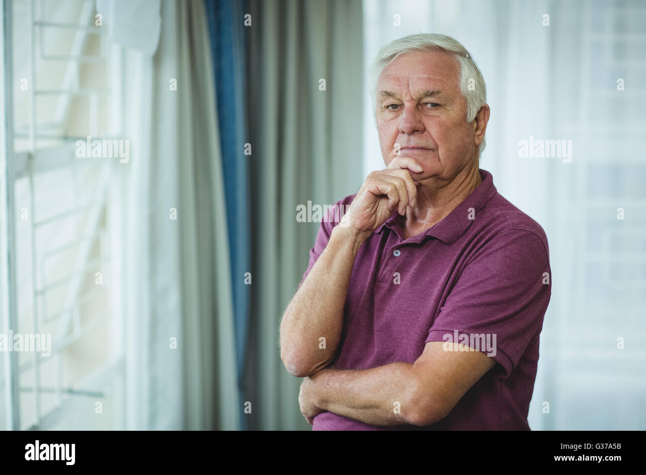 Retrato de altos hombre de pie con la mano en la barbilla Foto de stock