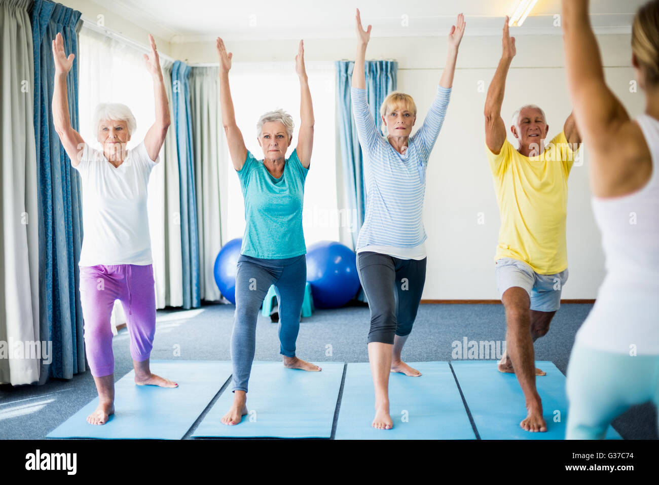 Instructor de yoga realizar con los ancianos Foto de stock