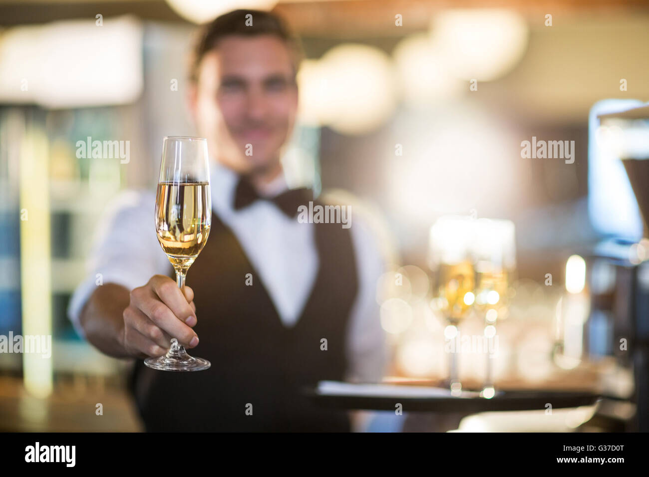 Camarero ofreciendo una copa de champaña. Foto de stock