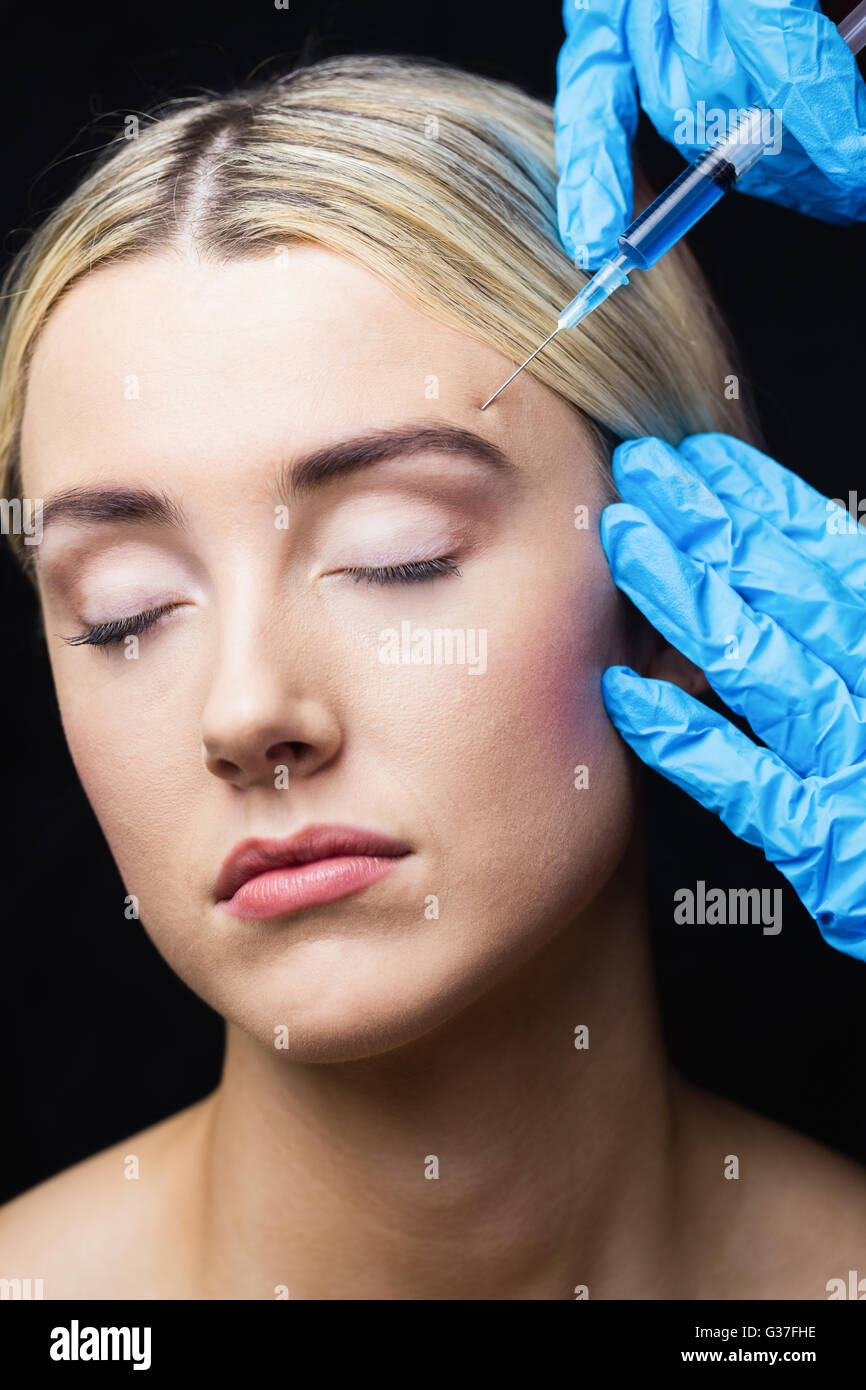 La mujer que recibe la inyección de Botox en su frente Foto de stock