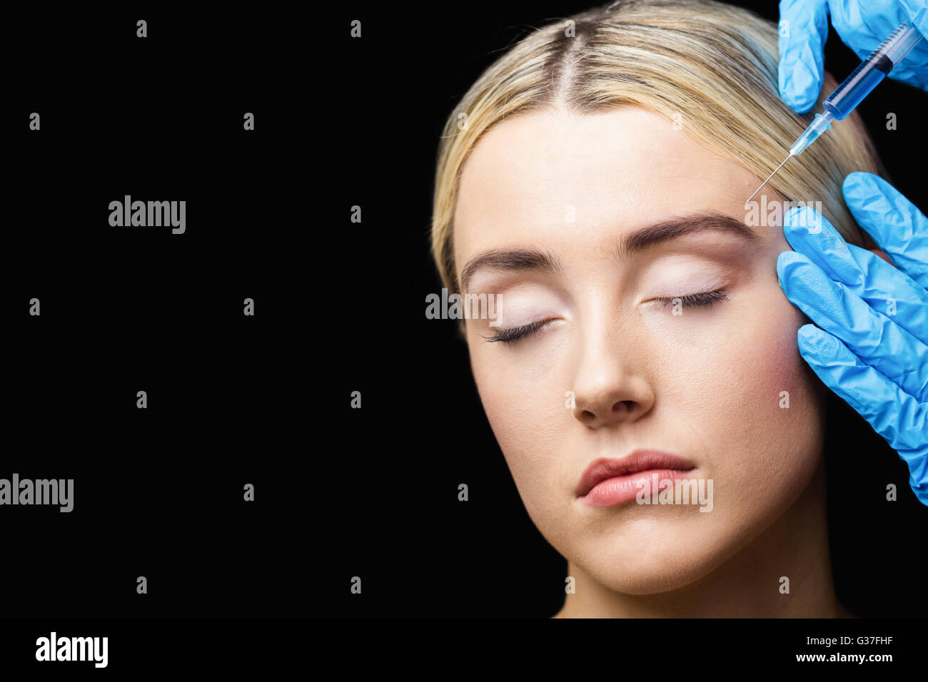 La mujer que recibe la inyección de Botox en su frente Foto de stock