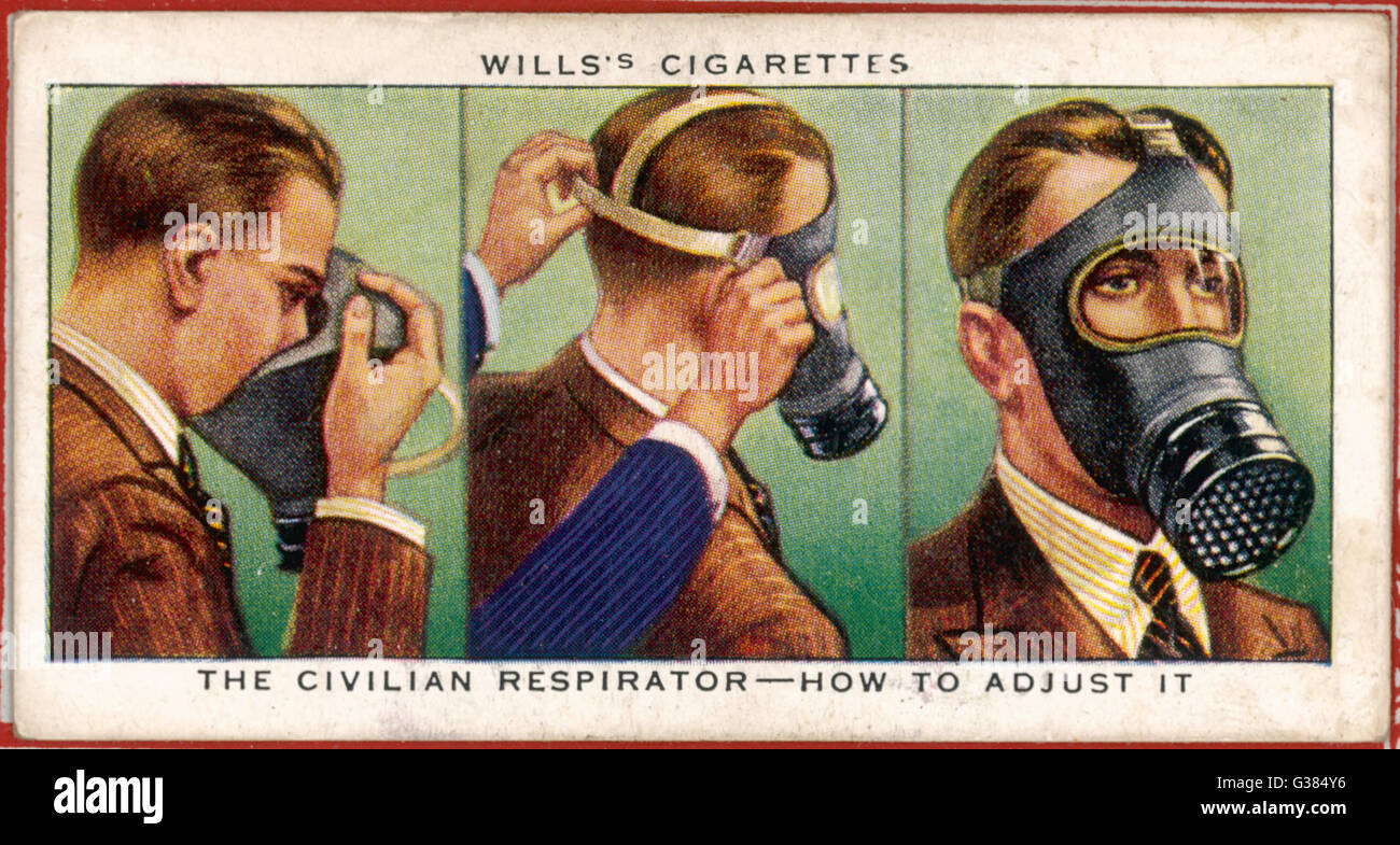 Un hombre muestra cómo poner una máscara antigás. Fecha: circa 1940 Foto de stock