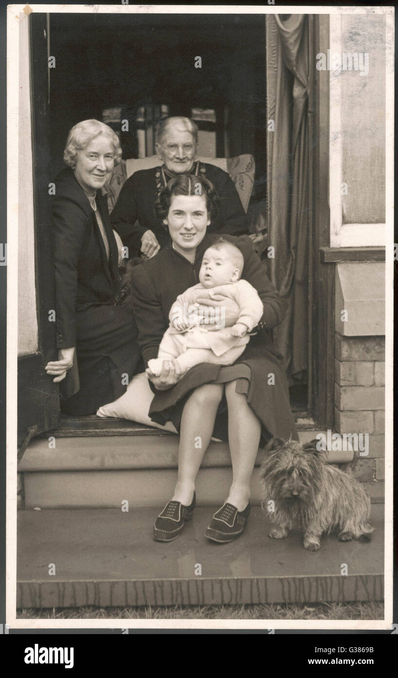 Cuatro generaciones de mujeres sentadas en un portal - y un perro Fecha: circa 1940 Foto de stock