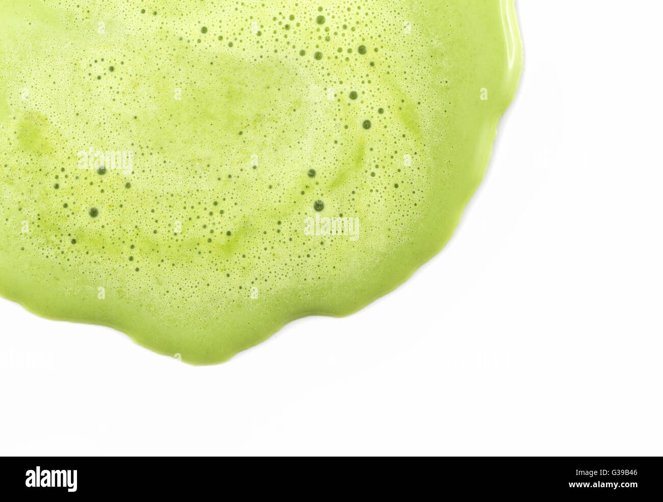 Antecedentes del enfoque cercano sobre fusión helado de té verde con una pequeña burbuja de aire en la superficie. Se derrite y el flujo sobre fondo blanco. Foto de stock