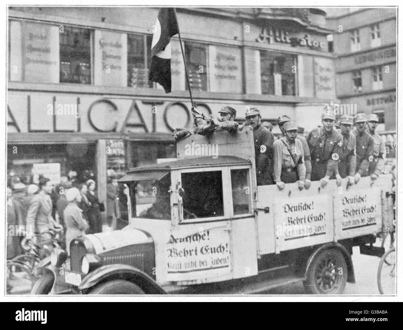 Los soldados nazis desalentar a la gente de Berlín del condescendiente tiendas propiedad de judíos. No conduzca alrededor del centro de la ciudad en un camión mostrar elementos de propaganda. Fecha: 1 de abril de 1933 Foto de stock