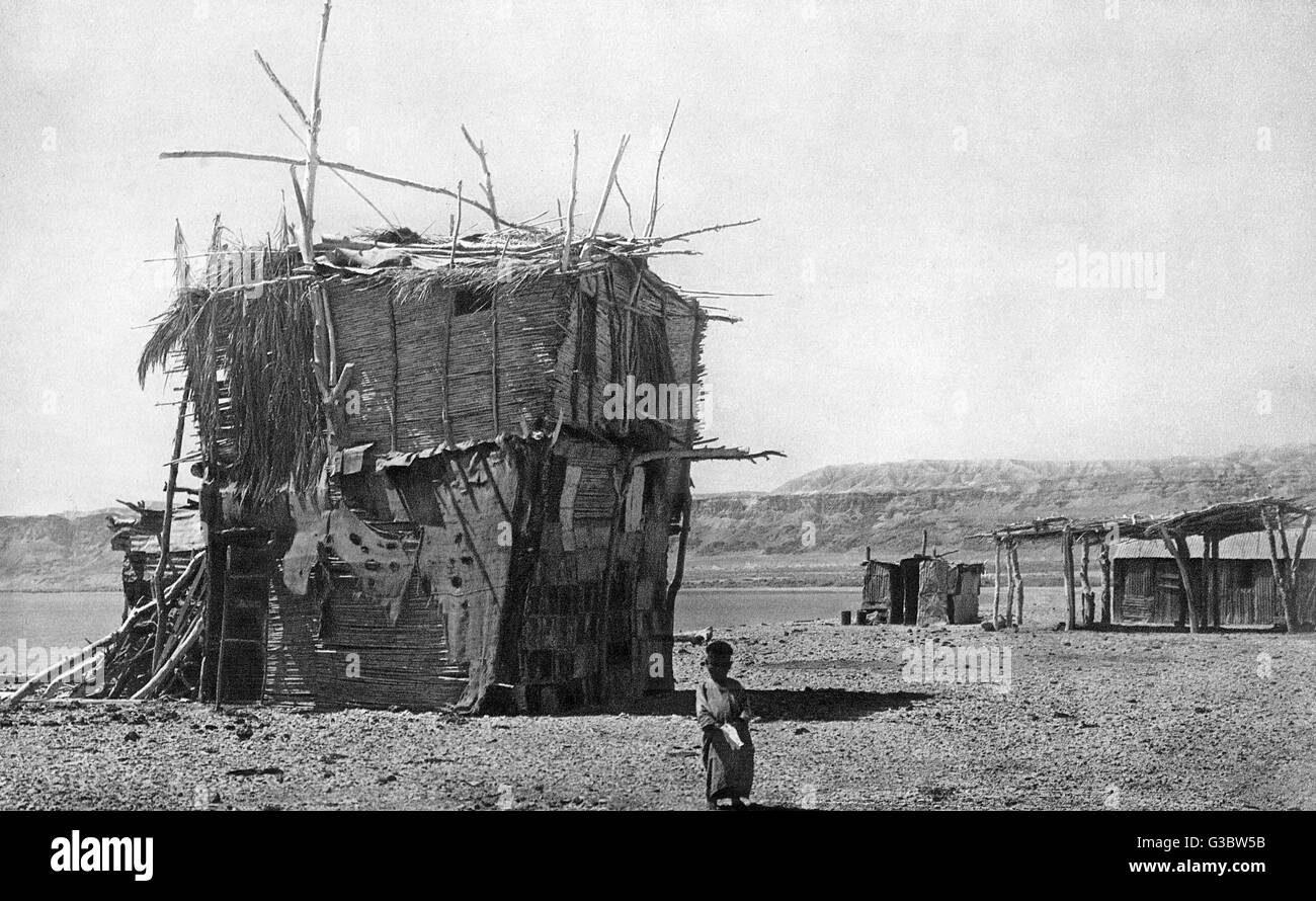 Una choza rudimentaria construida por un árabe fellah (campesino, agricultor o trabajador agrícola), por el Mar Muerto, Tierra Santa. Está hecho de palos, esteras y latas de aceite. Fecha: 1920 Foto de stock