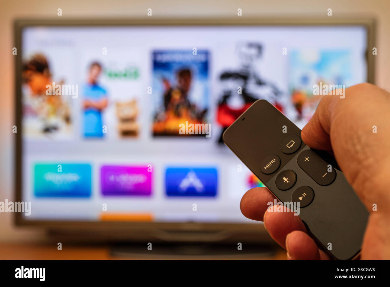 Mano con Apple TV remote, Apple TV 4ª generación de televisores LCD, las mejores  películas, desenfoque Fotografía de stock - Alamy