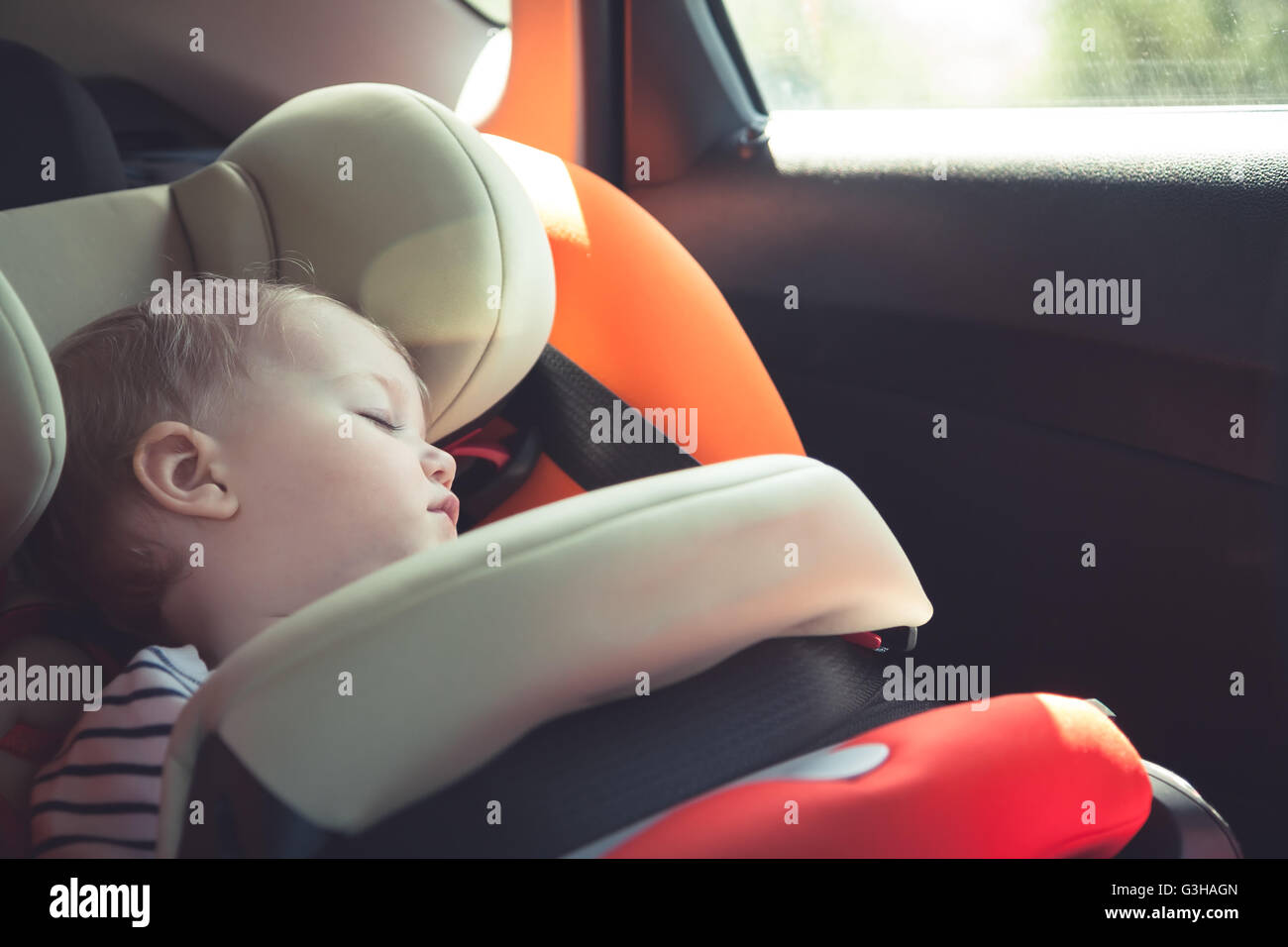 Bebe Durmiendo en el asiento de seguridad para automóvil mientras viaja Foto de stock