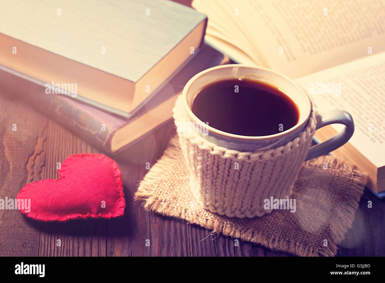 Taza de café y libros antiguos y un corazón Foto de stock