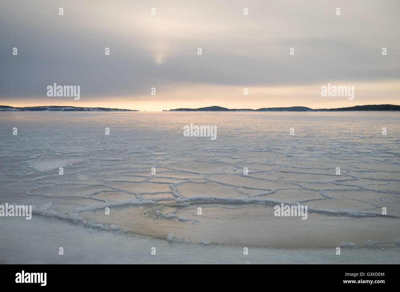 Sol bajo en el horizonte sobre el mar de hielo en el archipiélago fuera de Örnsköldsvik en la parte septentrional de Suecia Foto de stock