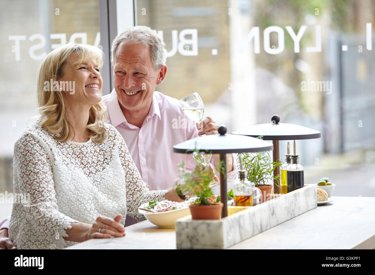 Mature Dating pareja reírse de la comida en un restaurante, Londres, Reino Unido. Foto de stock