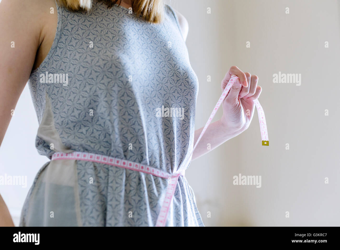 Vista recortada de la mujer la medición con cinta métrica de cintura Foto de stock