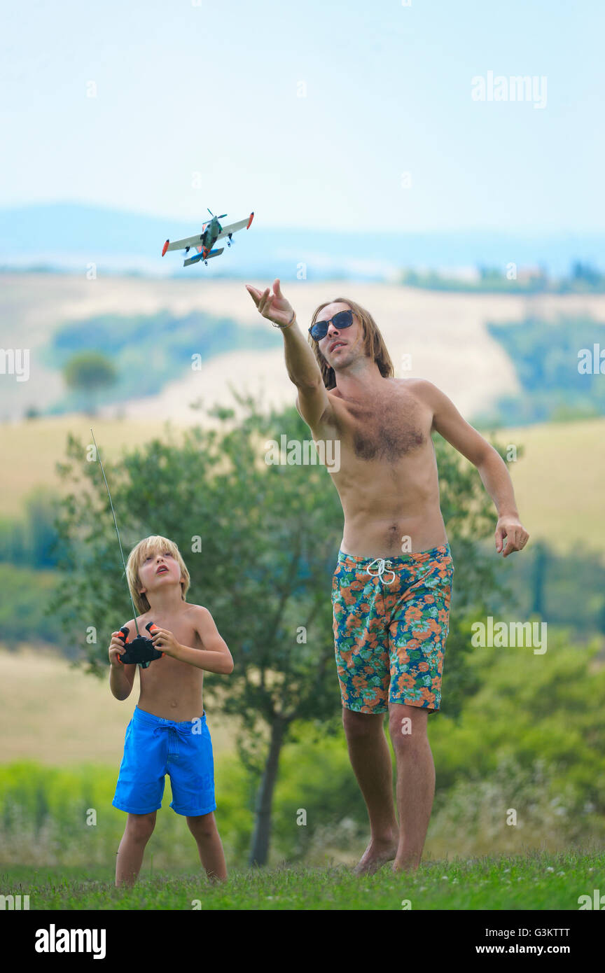 Padre e hijo volando afuera del plano de control remoto Foto de stock