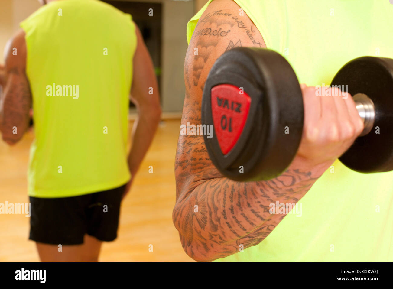 Imagen de espejo del hombre en gimnasio utilizando pesa Foto de stock