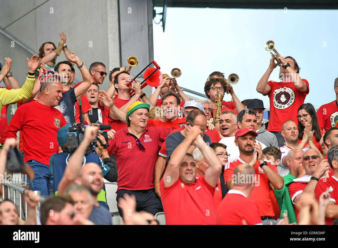 Euro 2016 - Gales v Eslovaquia : Hinchas de fútbol galés literalmente soplar su trompeta con la ayuda de los "Cuernos" de Barry Welsh viajar partidarios banda en la segunda mitad. En el estadio Stade de Bordeaux en Bordeaux, Francia, hoy. Foto de stock