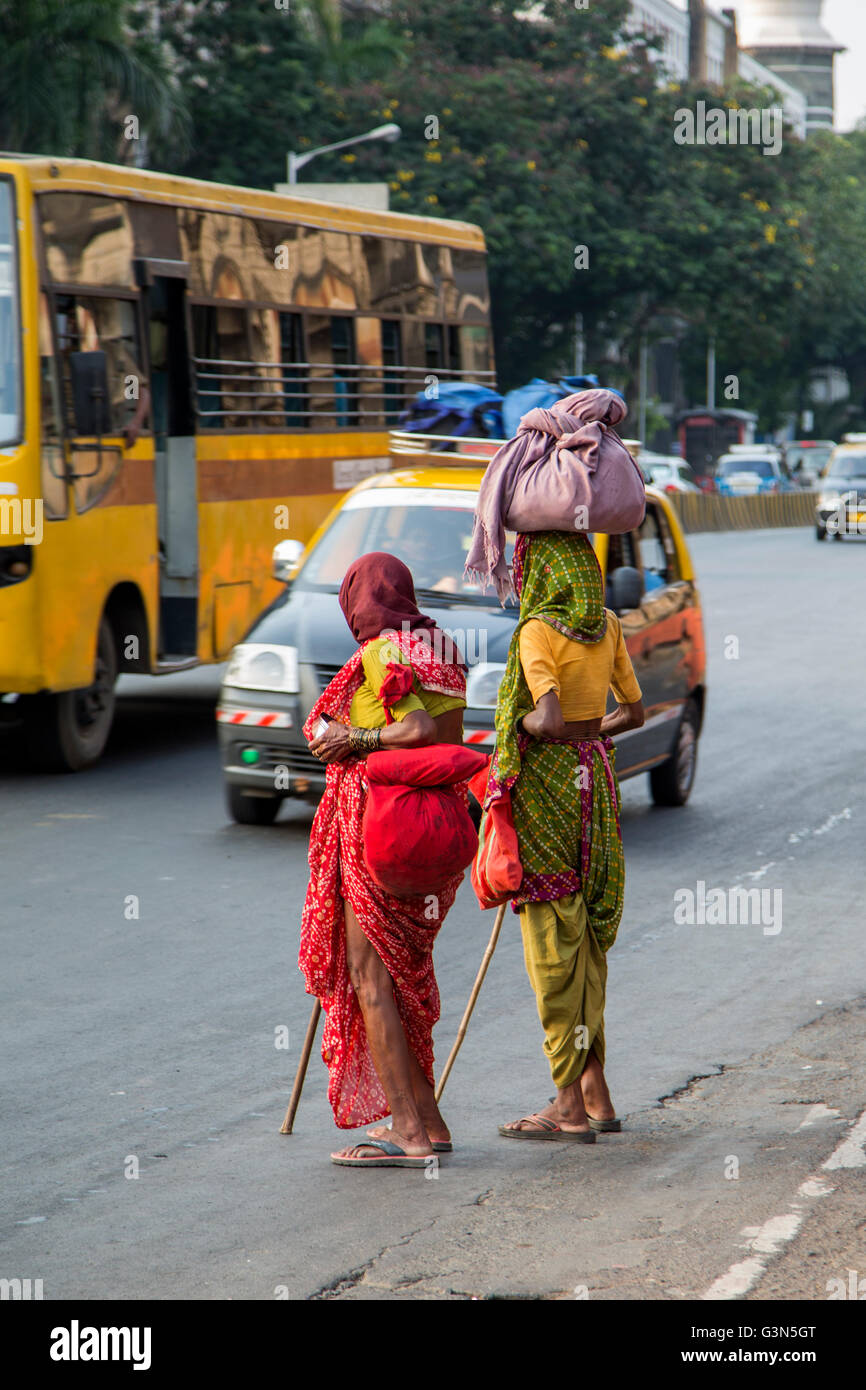 MUMBAI, India - Octubre 9, 2015: mujeres no identificadas, acarrear pesos en Mumbai. Las personas han transportado cargas equilibradas en la parte superior de t Foto de stock