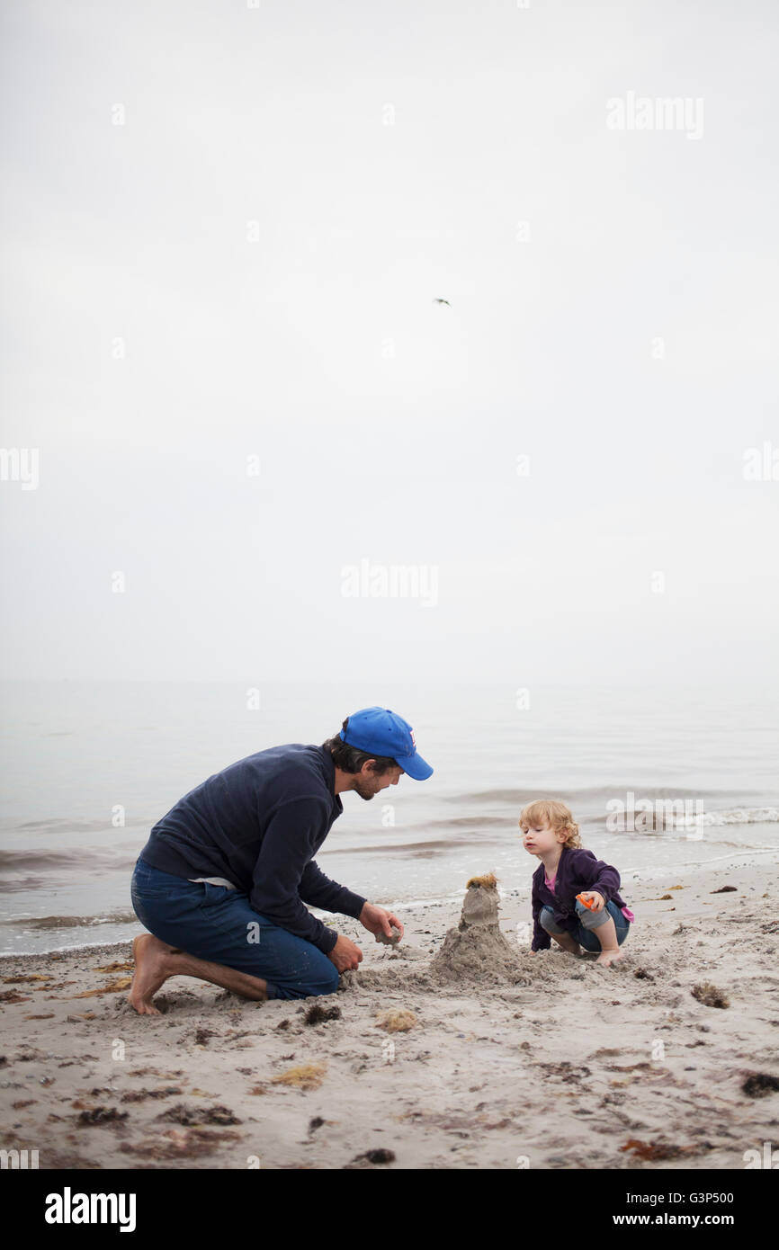 Suecia, Skane, Osterlen, Papá construyendo castillos de arena con su hija (2-3) Foto de stock