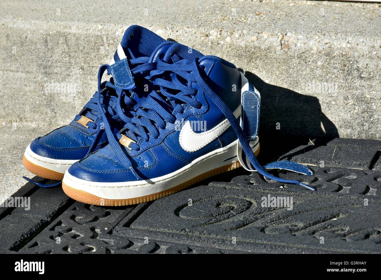 Un par de zapatillas Nike azul sentado en una esterilla delante de la puerta Fotografía de stock - Alamy