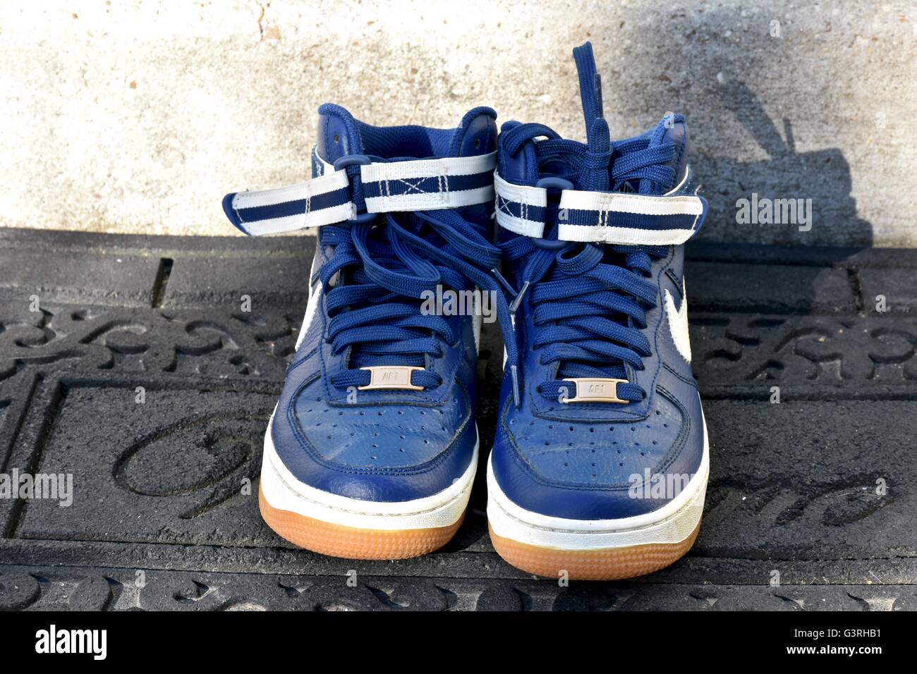 Un par de zapatillas Nike azul sentado en una esterilla delante de la puerta  de una casa Fotografía de stock - Alamy
