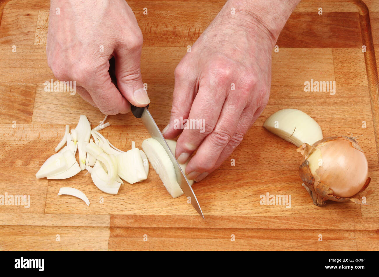 Primer plano de manos picar cebolla sobre una plancha de madera junta choppiing Foto de stock